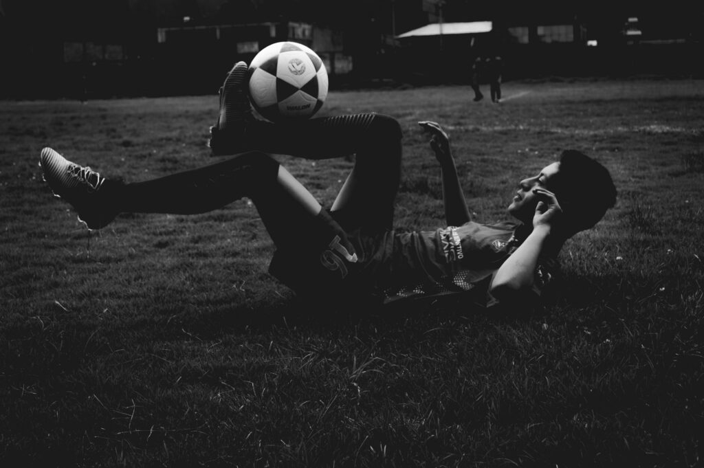 soccer player controlling the ball whilst lying on his back focussing on one of the 5cs of Soccer psychology